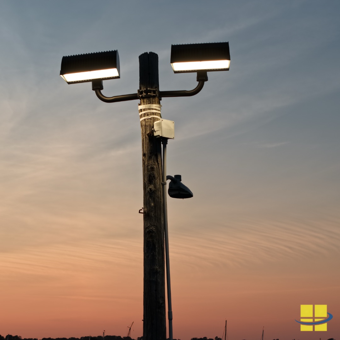 Twin APTI 600 LED sport lights mounted on a 30-foot wood pole at sunset at the Corinthian Yacht Club in Marblehead, MA — showing the AF99XW2 twin arm wood pole mount and backlight shielding